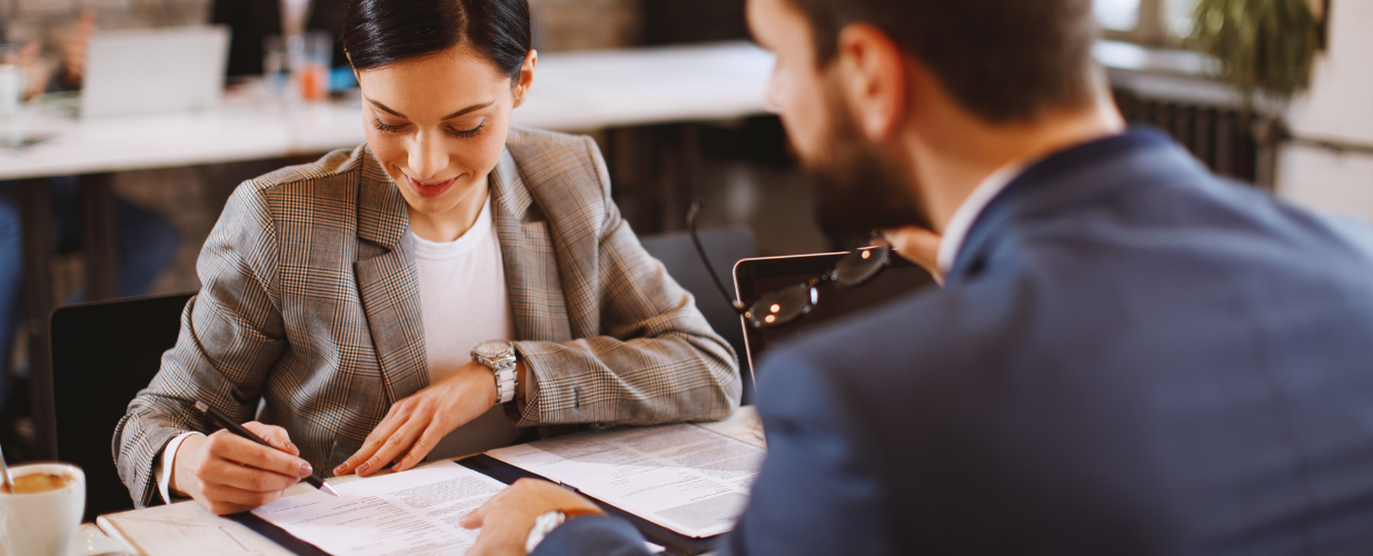 Business owner questioning a PPC agency across a meeting table before signing a contract