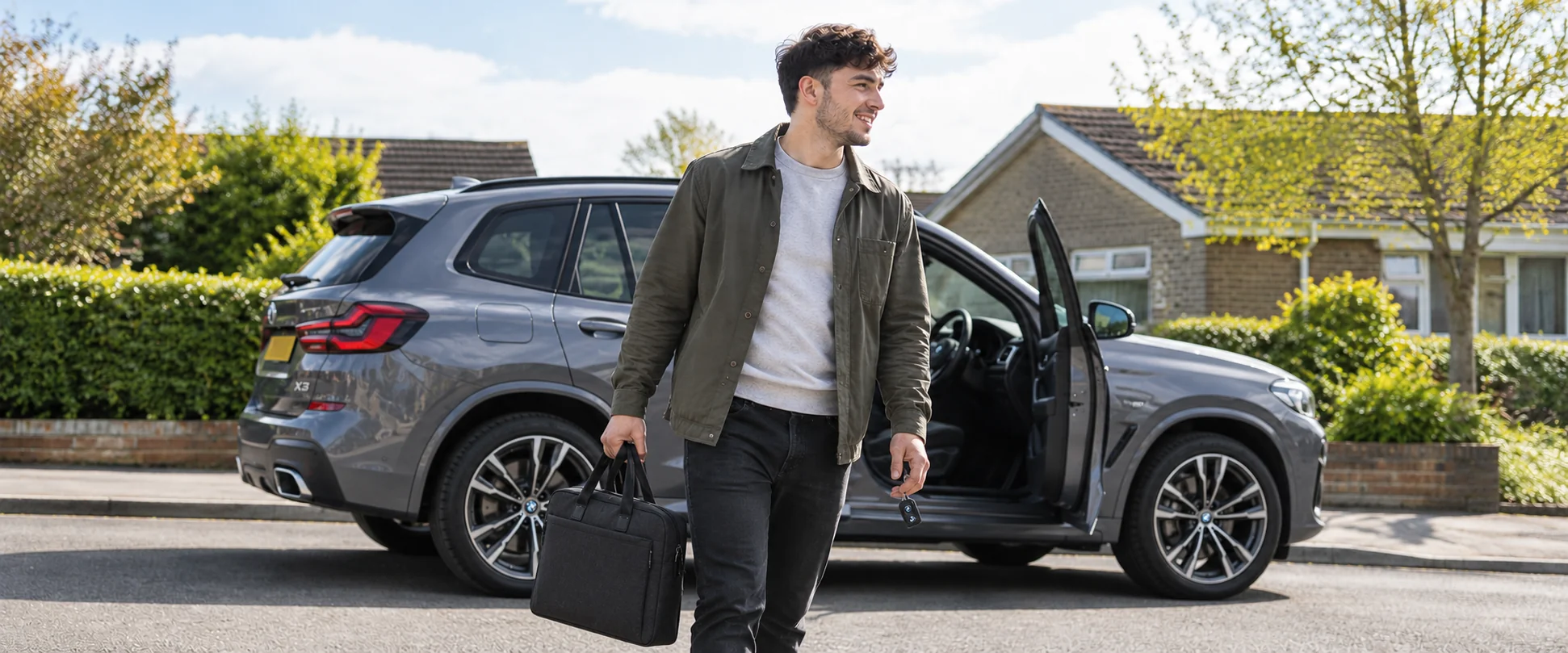 Illustrative scene beside a grey BMW SUV, with a structured work bag.